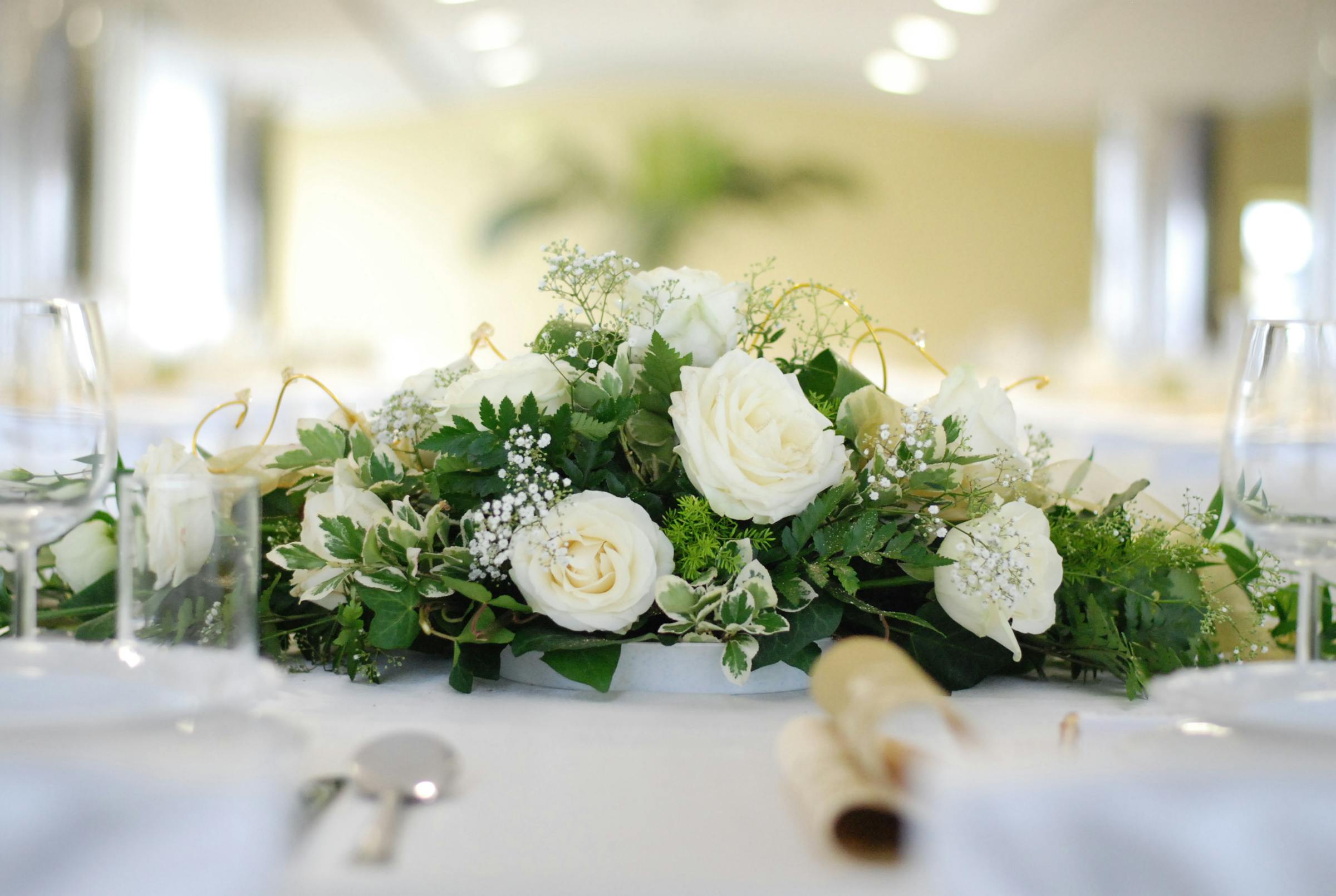 Florale Tischdekoration in Weiss und Gruen